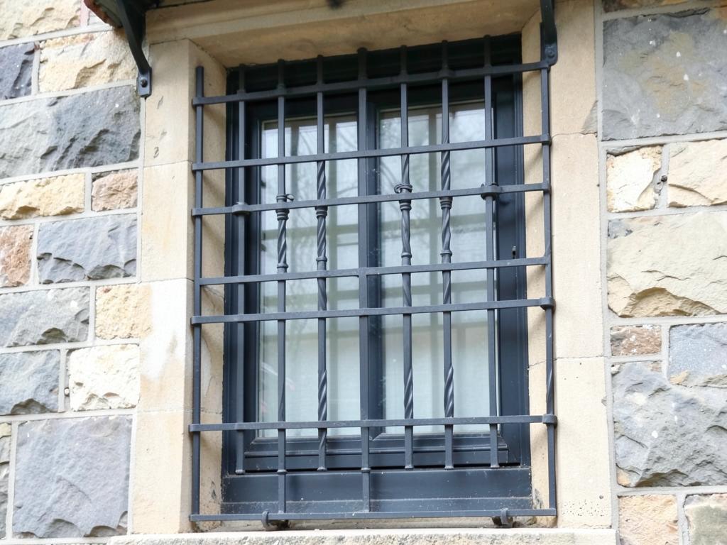 Grille de défense en fer forgé posée sur une fenêtre